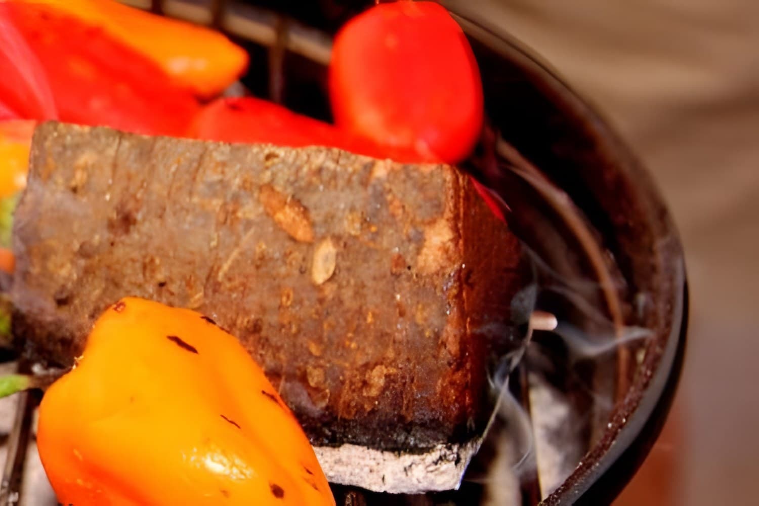 A steak and peppers on the grill