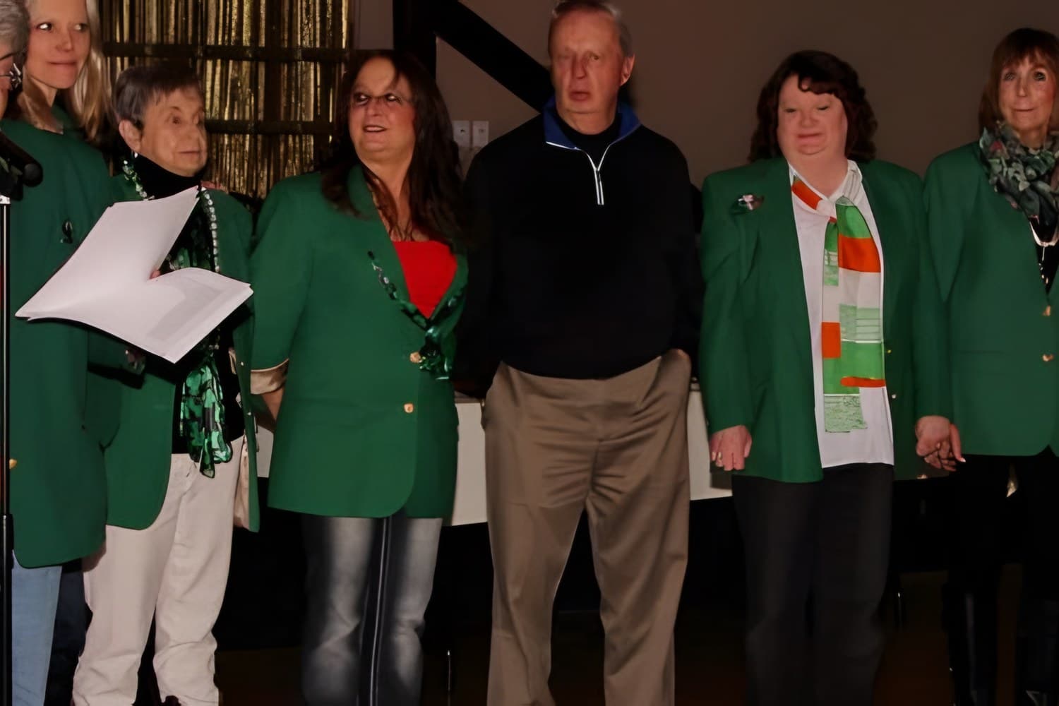 Shamrock Award volunteers in green jackets on stage at the Grand Marshal celebration