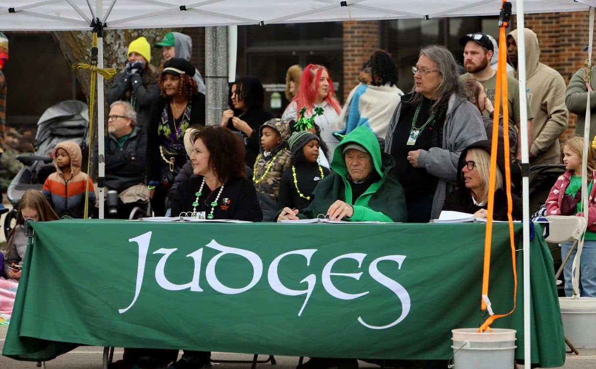 Parade judges score entries at the green Judges table