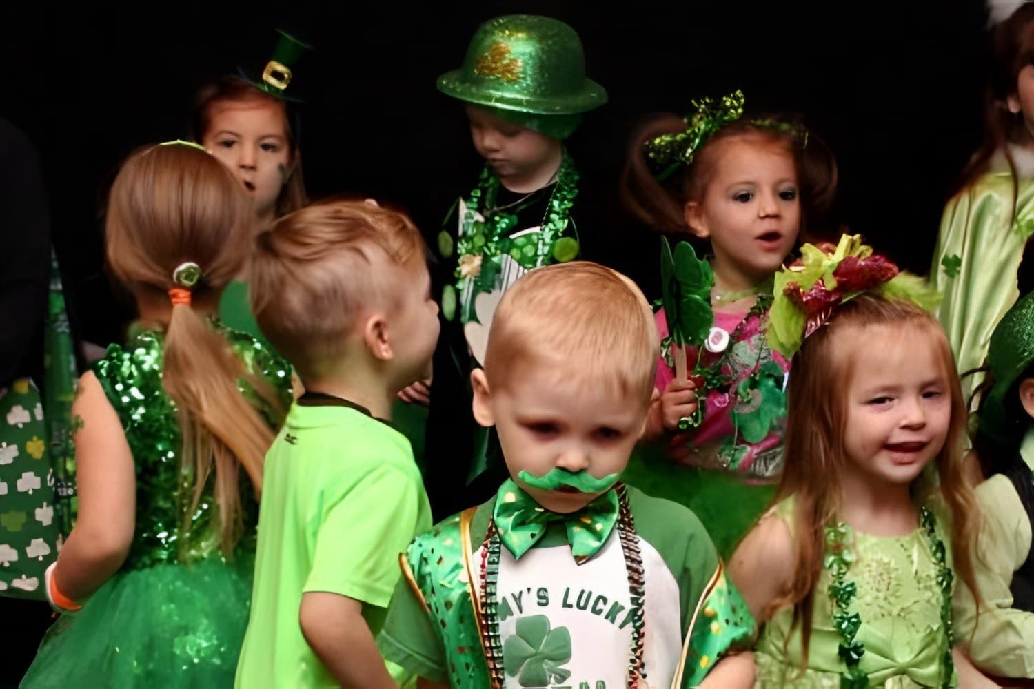 Lads & Lassies contestants in green outfits and hats on stage